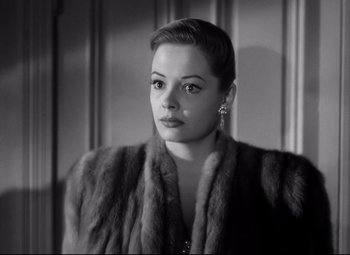 Movie still from “Out of the Past” (1947), directed by Jacques Tourneur – A black and white photo of a woman wearing a fur coat; Close Up shot, Low angle