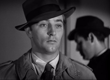 Movie still from “Out of the Past” (1947), directed by Jacques Tourneur – A black and white photo of a man wearing a hat; Close Up shot, Over the shoulder angle