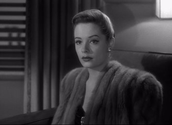 Movie still from “Out of the Past” (1947), directed by Jacques Tourneur – A black - and - white photo of a woman wearing a fur coat; Close Up shot, Over the shoulder angle