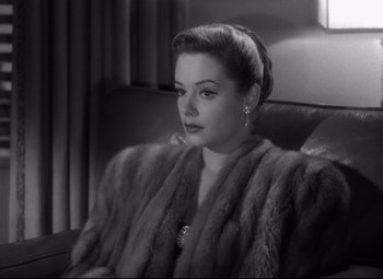 Movie still from “Out of the Past” (1947), directed by Jacques Tourneur – A black and white photo of a woman wearing a fur coat; Close Up shot, High angle