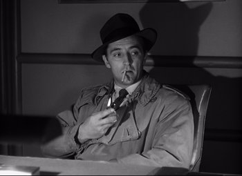 Movie still from “Out of the Past” (1947), directed by Jacques Tourneur – A black and white photo of a man smoking a cigarette; Medium shot, Over the shoulder angle