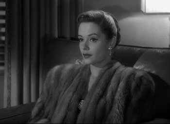 Movie still from “Out of the Past” (1947), directed by Jacques Tourneur – A black and white photo of a woman wearing a fur coat; Close Up shot, Over the shoulder angle