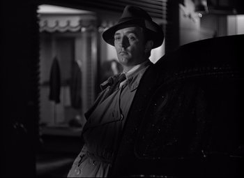 Movie still from “Out of the Past” (1947), directed by Jacques Tourneur – A black and white photo of a man wearing a hat; Medium shot, Low angle