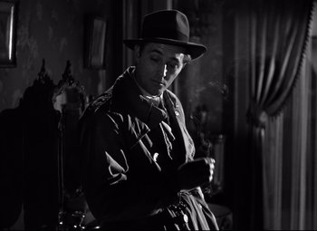 Movie still from “Out of the Past” (1947), directed by Jacques Tourneur – A black and white photo of a man smoking a cigarette; Close Up shot, Low angle