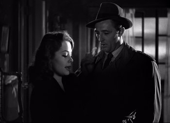 Movie still from “Out of the Past” (1947), directed by Jacques Tourneur – A man and a woman are standing next to each other; Close Up shot, Over the shoulder angle