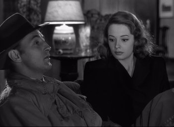 Movie still from “Out of the Past” (1947), directed by Jacques Tourneur – A man and a woman sitting next to each other in front of a lamp; Close Up shot, Over the shoulder angle