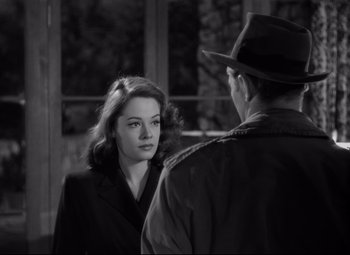 Movie still from “Out of the Past” (1947), directed by Jacques Tourneur – A man and a woman are standing next to each other in front of a window; Close Up shot, Over the shoulder angle