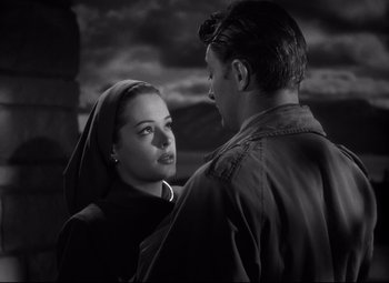 Movie still from “Out of the Past” (1947), directed by Jacques Tourneur – A man and a woman standing next to each other in front of a cloudy sky; Close Up shot, Low angle