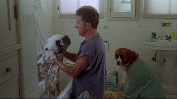 Movie still from “Outbreak” (1995), directed by Wolfgang Petersen – A man in a bathroom washing a dog; Medium shot, Over the shoulder angle
