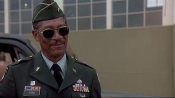Movie still from “Outbreak” (1995), directed by Wolfgang Petersen – A man in a military uniform wearing sunglasses; Close Up shot, Low angle