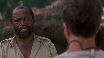 Movie still from “Outbreak” (1995), directed by Wolfgang Petersen – A man with a beard talking to another man in front of him; Close Up shot, Over the shoulder angle