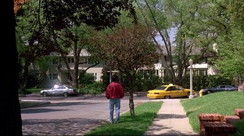 Movie still from “Outbreak” (1995), directed by Wolfgang Petersen – A man standing on the side of the road near a tree; Wide shot, Low angle