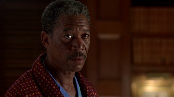 Movie still from “Outbreak” (1995), directed by Wolfgang Petersen – An older man is looking at the camera; Close Up shot, Over the shoulder angle