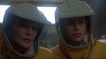 Movie still from “Outbreak” (1995), directed by Wolfgang Petersen – Two women in yellow jackets and white helmets; Close Up shot, Low angle