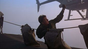 Movie still from “Outbreak” (1995), directed by Wolfgang Petersen – A man in a military uniform is climbing a helicopter; Medium shot, Low angle