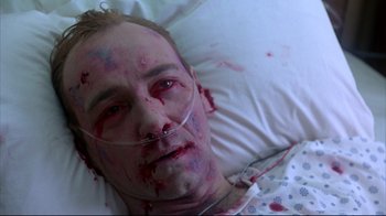Movie still from “Outbreak” (1995), directed by Wolfgang Petersen – A man in a hospital bed covered in blood; Close Up shot, Overhead angle