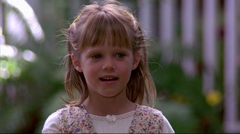 Movie still from “Outbreak” (1995), directed by Wolfgang Petersen – A little girl is smiling for the camera; Close Up shot, Over the shoulder angle