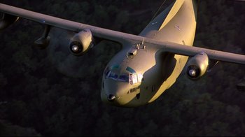 Movie still from “Outbreak” (1995), directed by Wolfgang Petersen – An airplane is flying through the air over the trees; Extreme Wide shot, Overhead angle