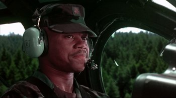 Movie still from “Outbreak” (1995), directed by Wolfgang Petersen – A man wearing a hat and ear muffs in a helicopter cockpit; Close Up shot, Low angle