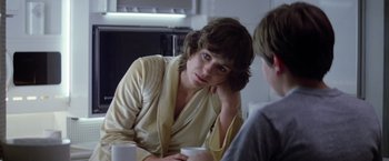 Movie still from “Outland” (1981), directed by Peter Hyams – A woman sitting at a table with a cup of coffee; Close Up shot, Over the shoulder angle