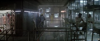 Movie still from “Outland” (1981), directed by Peter Hyams – A group of people standing around in a room; Wide shot, High angle