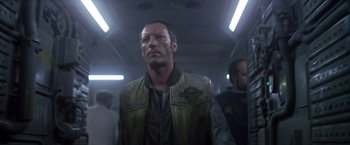 Movie still from “Outland” (1981), directed by Peter Hyams – A man in a green jacket standing in a room; Close Up shot, Low angle