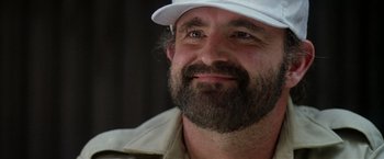Movie still from “Outland” (1981), directed by Peter Hyams – A man with a beard wearing a white hat; Close Up shot, Low angle