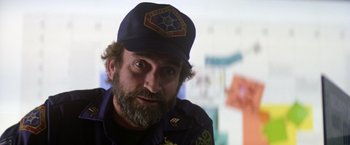 Movie still from “Outland” (1981), directed by Peter Hyams – A man with a beard wearing a hat; Close Up shot, Over the shoulder angle