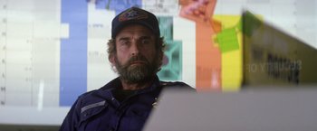 Movie still from “Outland” (1981), directed by Peter Hyams – A man with a beard wearing a hat and looking at the camera; Medium shot, Over the shoulder angle