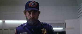Movie still from “Outland” (1981), directed by Peter Hyams – A man with a beard wearing a police uniform; Close Up shot, Low angle