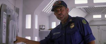 Movie still from “Outland” (1981), directed by Peter Hyams – A man in a police uniform is looking at the camera; Medium shot, Low angle