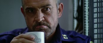 Movie still from “Outland” (1981), directed by Peter Hyams – A person holding a cup of coffee; Close Up shot, Low angle