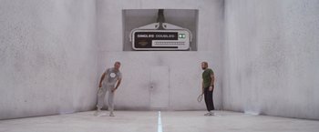 Movie still from “Outland” (1981), directed by Peter Hyams – Two men are playing doubles tennis on a court; Wide shot, Low angle