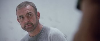 Movie still from “Outland” (1981), directed by Peter Hyams – A person wearing a gray shirt; Close Up shot, Low angle