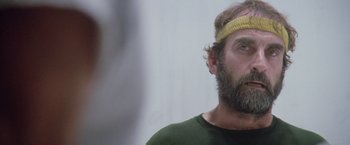 Movie still from “Outland” (1981), directed by Peter Hyams – A bearded man wearing a yellow head band; Close Up shot, Low angle