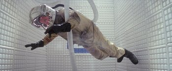 Movie still from “Outland” (1981), directed by Peter Hyams – A man in a spacesuit is hanging upside down; Wide shot, Overhead angle
