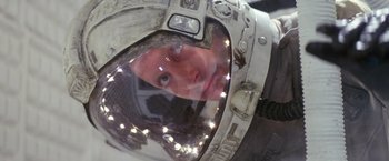 Movie still from “Outland” (1981), directed by Peter Hyams – A man in a space suit looking into a mirror; Close Up shot, Overhead angle