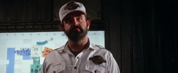 Movie still from “Outland” (1981), directed by Peter Hyams – A man in a white shirt wearing a hat; Close Up shot, Low angle