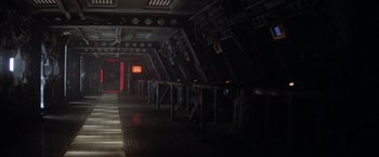 Movie still from “Outland” (1981), directed by Peter Hyams – A dark room with a lot of lights on the wall; Extreme Wide shot, High angle