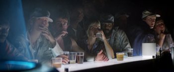 Movie still from “Outland” (1981), directed by Peter Hyams – A group of people sitting at a table with drinks; Medium shot, Low angle