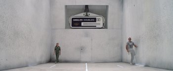 Movie still from “Outland” (1981), directed by Peter Hyams – A man standing in front of a wall; Wide shot, Low angle