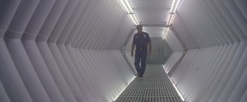 Movie still from “Outland” (1981), directed by Peter Hyams – A police officer walking down a hallway in a tunnel; Wide shot, Low angle