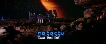 Movie still from “Outland” (1981), directed by Peter Hyams – An image of an image of a digital clock in the middle of the night; Wide shot, High angle