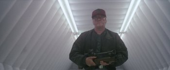 Movie still from “Outland” (1981), directed by Peter Hyams – A man holding a rifle in a room; Medium shot, Low angle