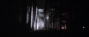 Movie still from “Outland” (1981), directed by Peter Hyams – A dark room with a lot of light coming from the windows; Extreme Wide shot, Low angle