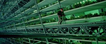 Movie still from “Outland” (1981), directed by Peter Hyams – A man standing on top of a platform in a greenhouse; Wide shot, High angle