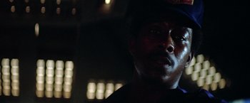 Movie still from “Outland” (1981), directed by Peter Hyams – A person wearing a hat in the dark; Close Up shot, Low angle