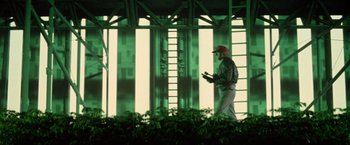 Movie still from “Outland” (1981), directed by Peter Hyams – A man standing in front of a green building; Wide shot, Low angle