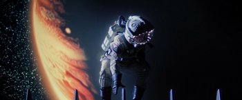 Movie still from “Outland” (1981), directed by Peter Hyams – A person in a spacesuit is standing on some poles; Wide shot, Low angle