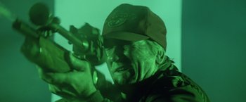 Movie still from “Outland” (1981), directed by Peter Hyams – An old man wearing a hat and holding a camera; Close Up shot, High angle